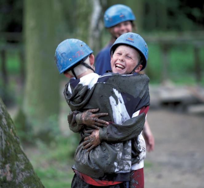 Boys hugging covered in mud